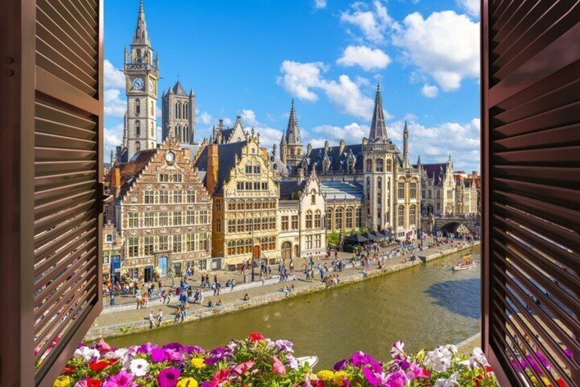 A riverside view of historic buildings with a clock tower, a bridge, and a river. 2