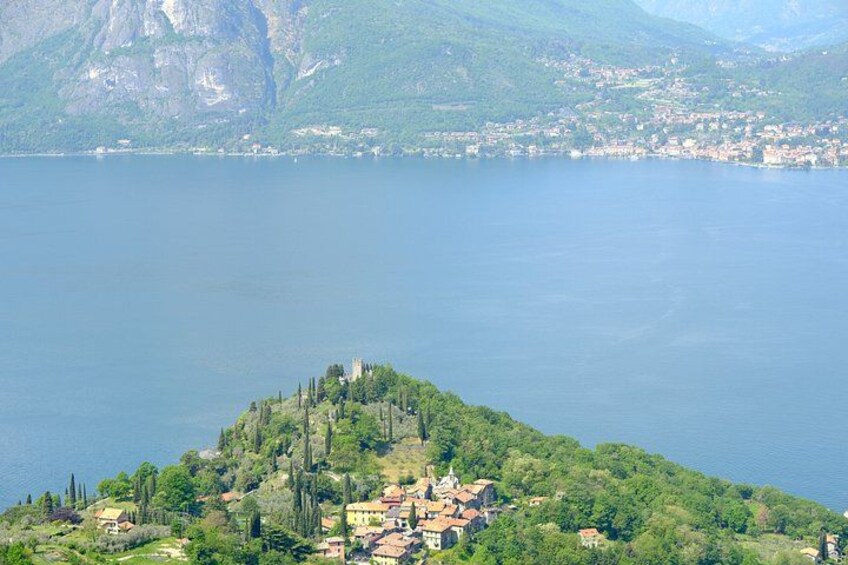 A lake surrounded by mountains and a small village with buildings and trees. 2