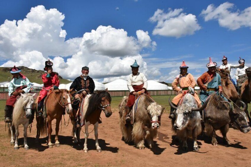 A group of people on horseback in a rural setting with tents in the background. 5