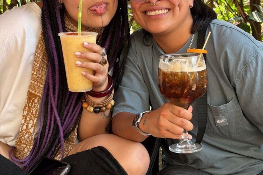 Two people holding drinks, one with a straw and the other with a straw and a slice of lime. 2