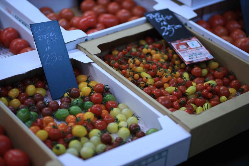 A variety of cherry tomatoes in boxes at a market. 4