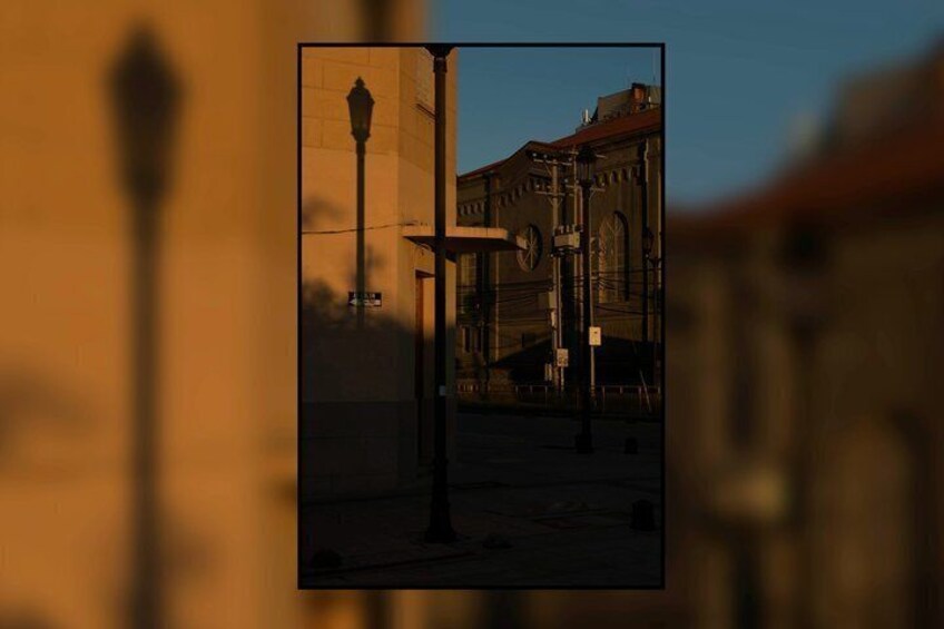 A street scene with a lamppost, a building with arched windows, and a clear sky. 4