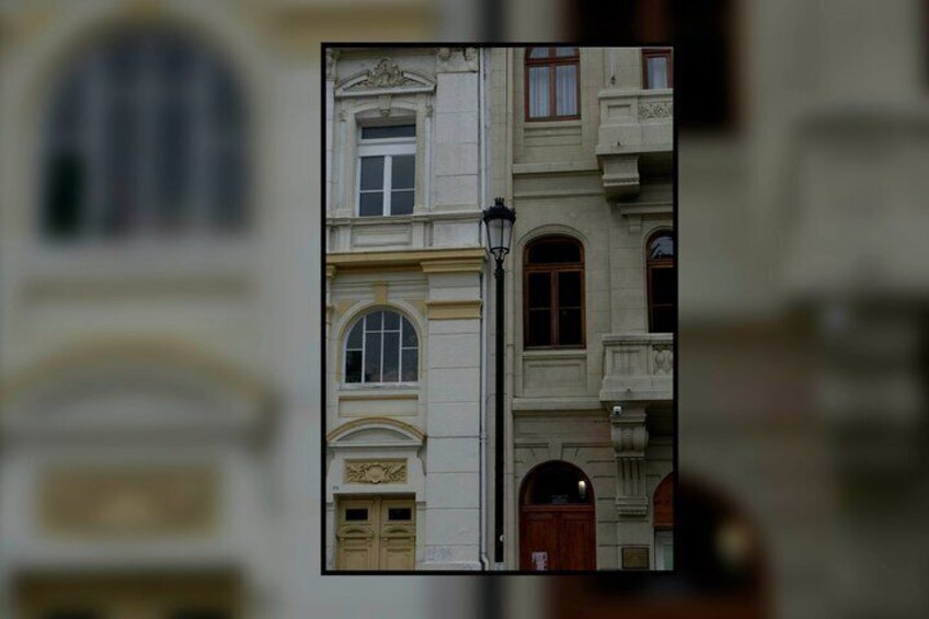 A classical building facade with arched windows and a wooden door. 2