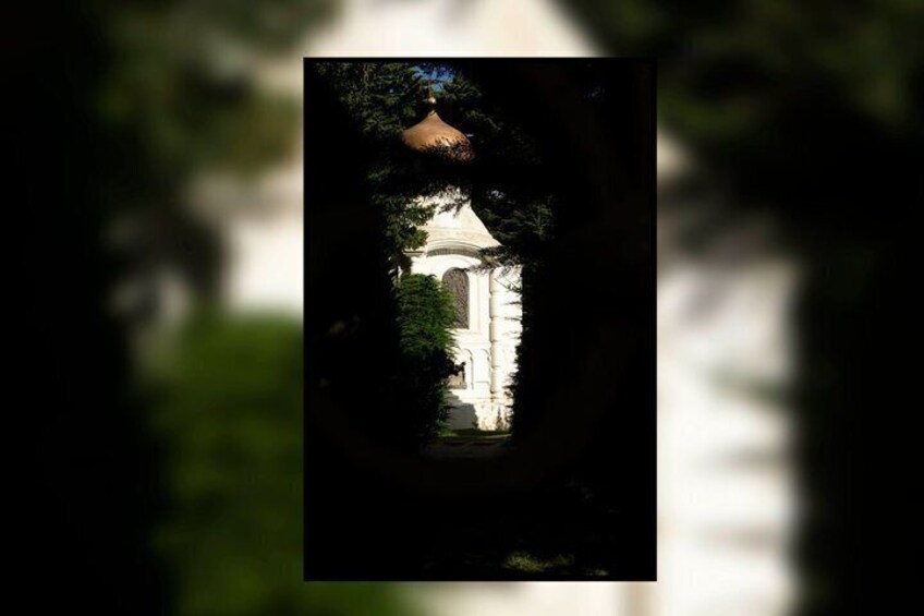 A building with a dome and a bell tower, surrounded by trees. 3