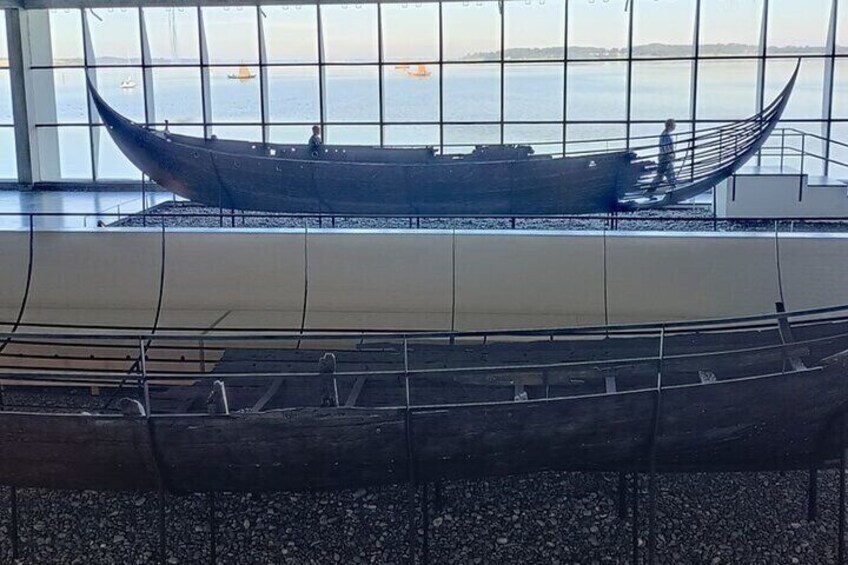 A museum exhibit with two boats, one on display and one in storage. 2