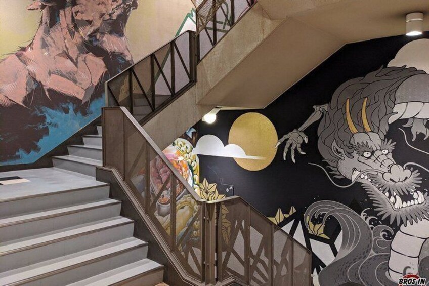 A staircase with a mural of a dragon and a sun. 3