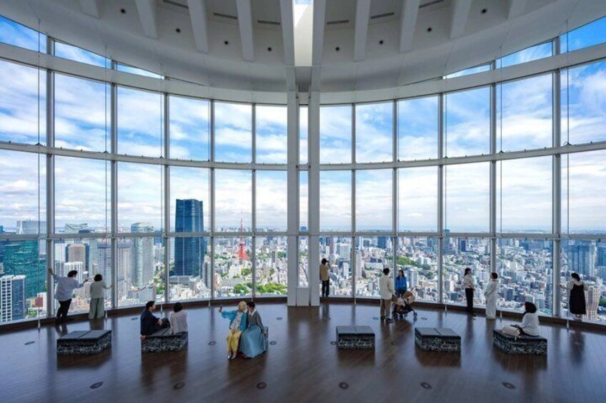 A spacious room with large windows overlooking a cityscape. 1
