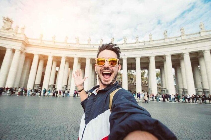 A person taking a selfie in front of a large, classical building with columns. 3