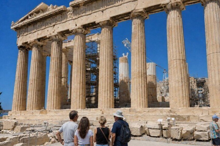 The Parthenon in Athens with tourists observing the ancient structure. 1