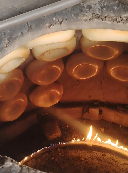 A close-up of a cooking process with round, golden-brown objects and a visible flame. 2