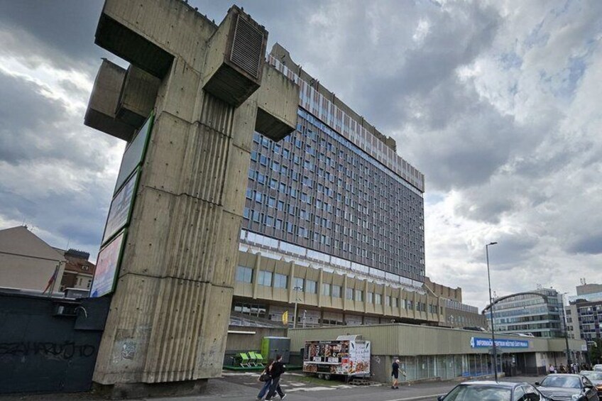 A large building with a unique architectural design, featuring a prominent concrete structure on the left. 1