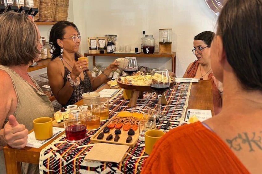 A group of people sitting around a table with food and drinks, engaged in conversation. 5