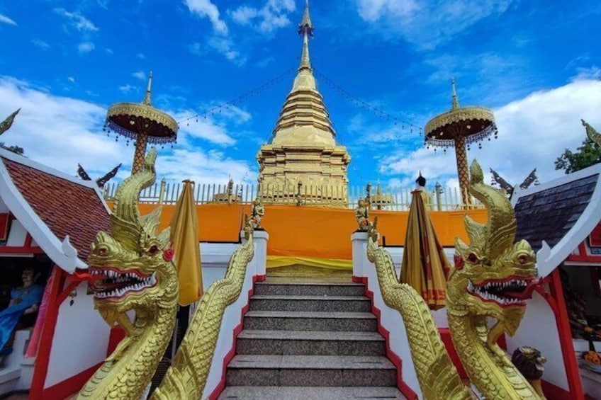 A temple with a golden spire, a staircase, and two golden dragon statues. 5