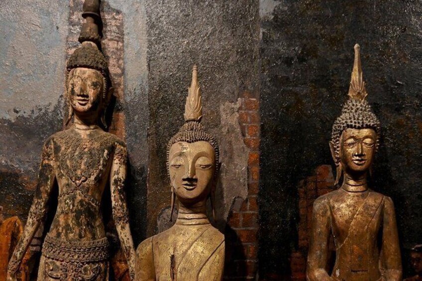 Three statues of Buddha in a weathered temple setting. 3