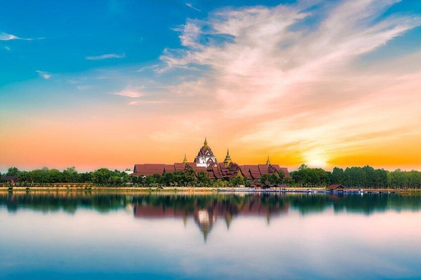 A temple complex with a reflection in calm water, surrounded by trees and a clear sky. 2