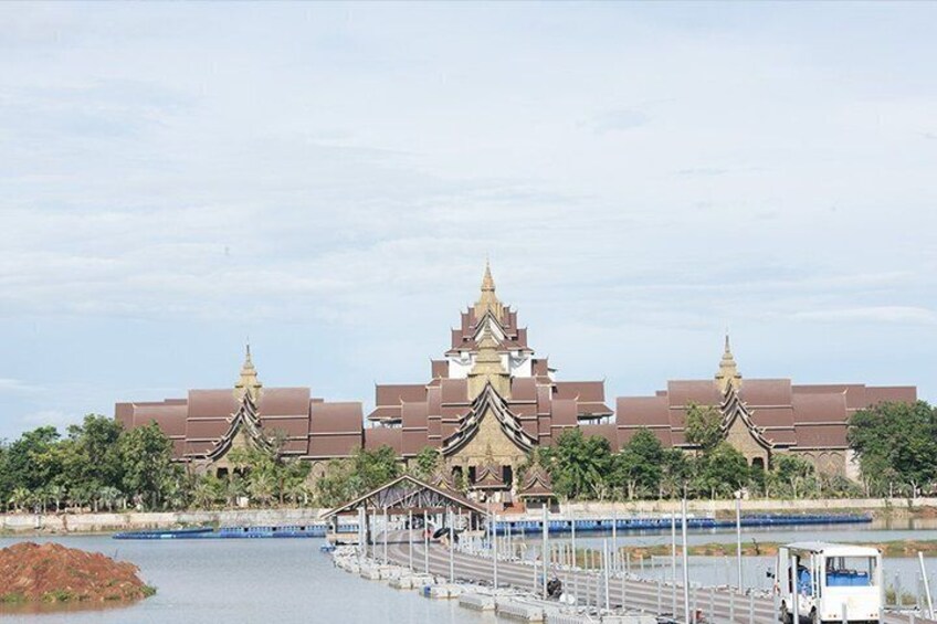 A traditional temple complex with multiple pagodas, a river, and a small boat docked near the shore. 5