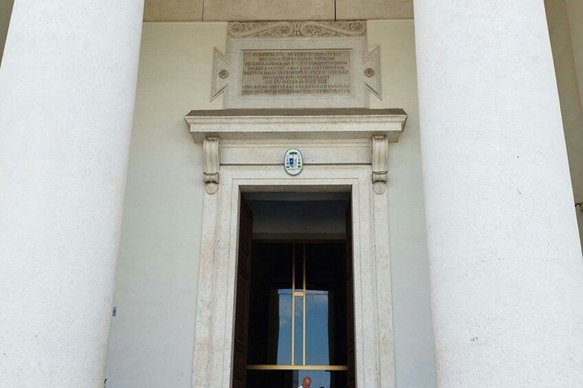 A building facade with a plaque and a door. 2