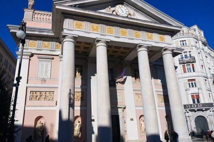 A classical building with columns, statues, and a clock. 5