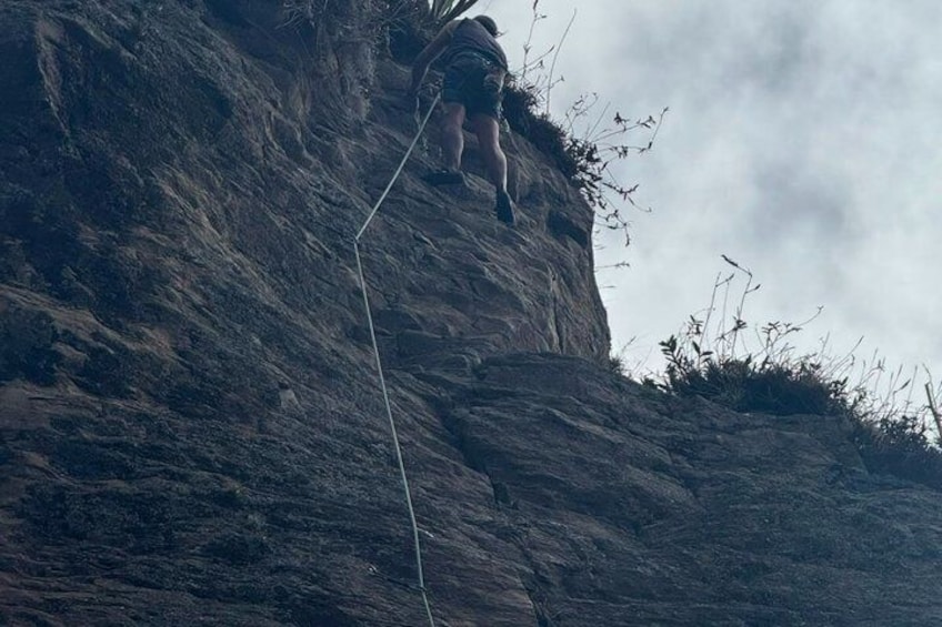 A person climbing a rocky cliff. 3