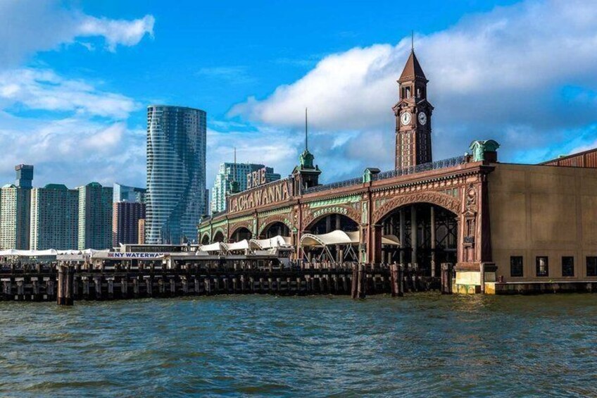 A historic bridge with a clock tower, a modern skyscraper, and a water body. 2