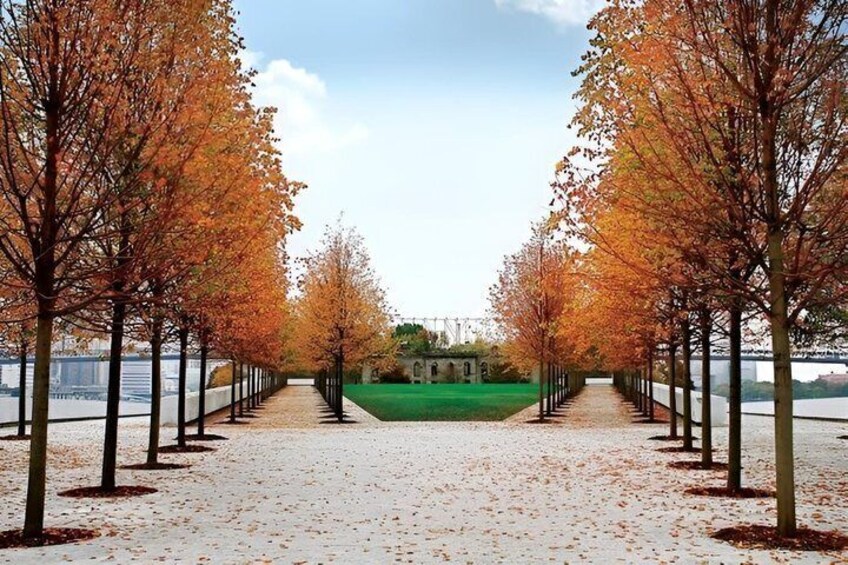 A pathway lined with trees, a grassy area, and a distant building. 4