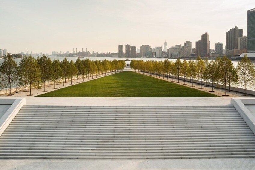 A riverside walkway with a city skyline in the background. 3