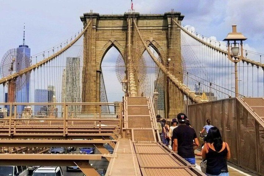 A bridge with pedestrians, a city skyline in the background, and a clear sky. 5