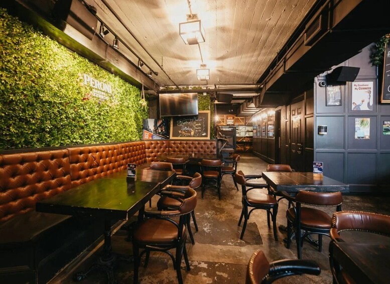 A cozy restaurant with a green wall, leather booth seating, and wooden tables. 4