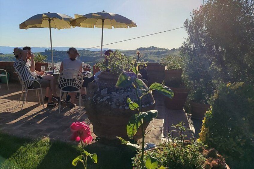 A patio with outdoor seating, a large planter, and a view of the countryside. 4