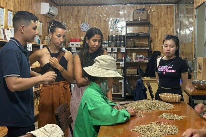 A group of people in a rustic indoor setting with wooden walls and shelves filled with items. 1