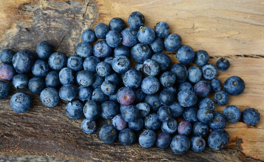 A pile of blueberries on a wooden surface. 3