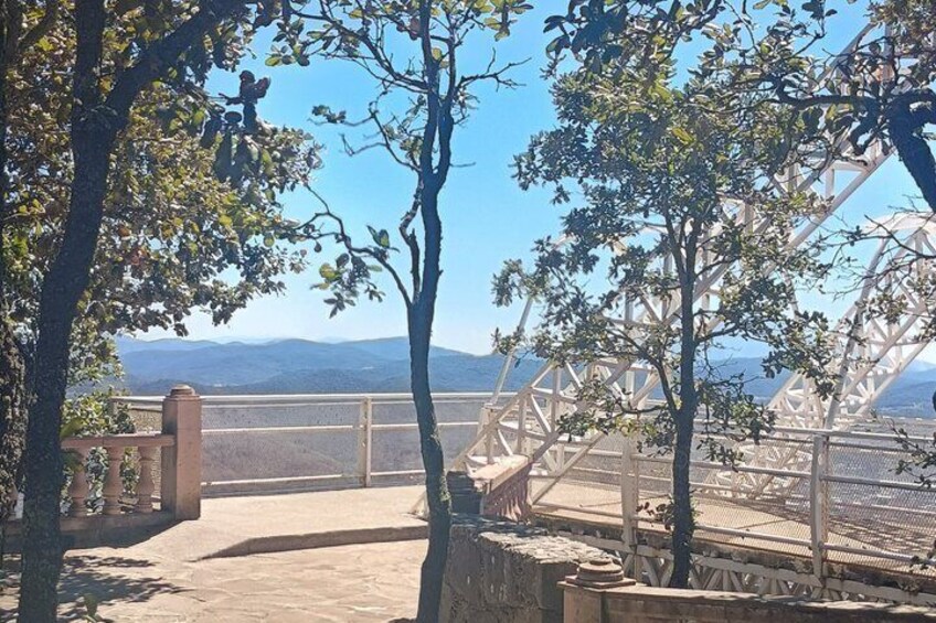 A bridge with a metal framework, trees, and a distant mountain range. 4