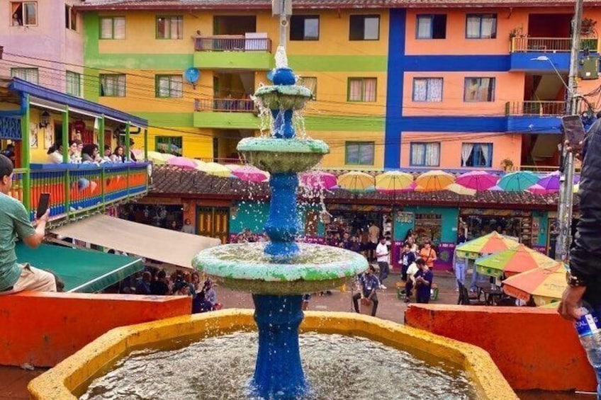 A colorful fountain in a public square with buildings in the background. 2