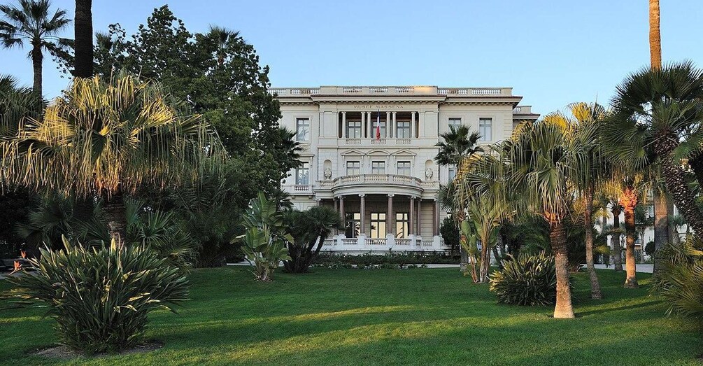 A grand building with columns and a well-manicured lawn. 2