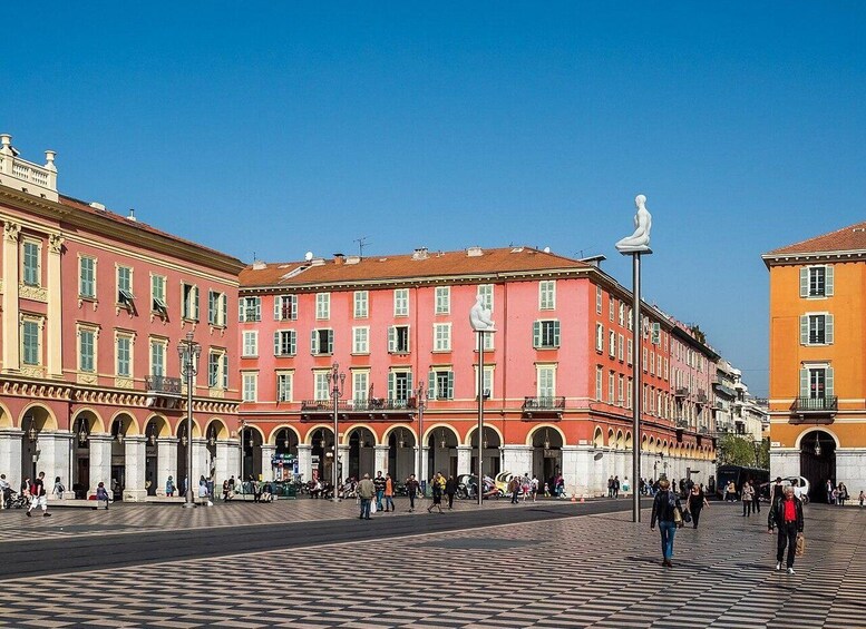 A historic square with ornate buildings, a statue, and a tiled pavement. 5