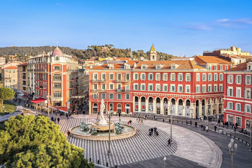 A historic square with a central fountain, surrounded by colorful buildings with red and white facades. 4