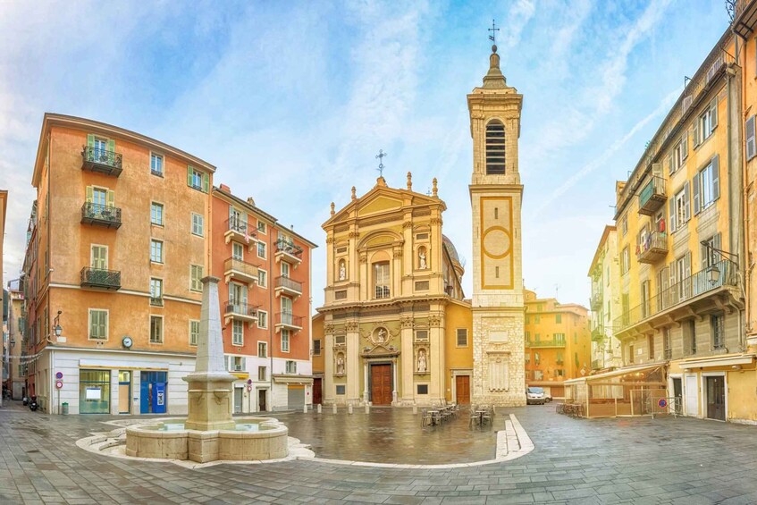 A historic square with a church, a fountain, and surrounding buildings. 3