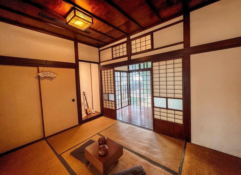 A traditional Japanese room with tatami flooring, sliding doors, and a hanging lantern. 5