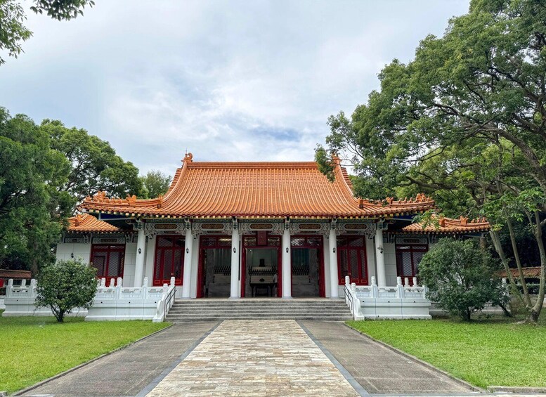 A traditional Chinese building with a tiled roof, red doors, and white columns. 2