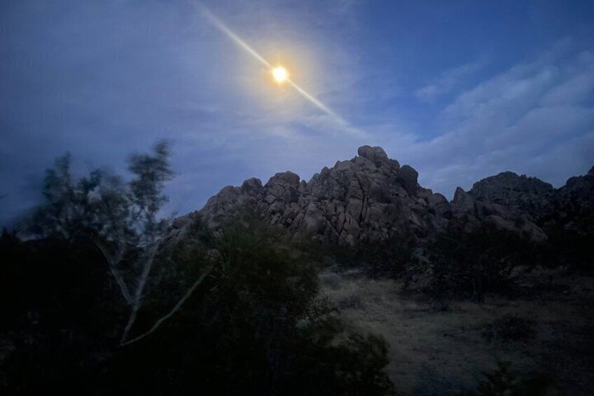 A mountain range at dusk with a visible moon. 1