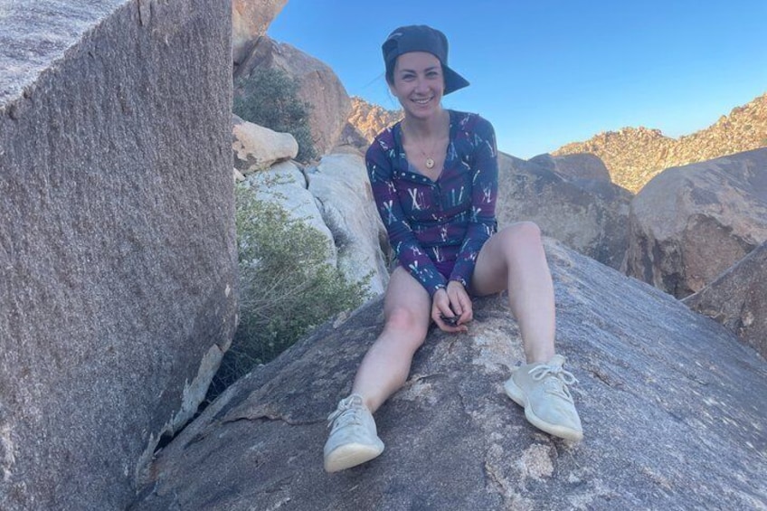 A person sitting on a rock with a mountainous landscape in the background. 3
