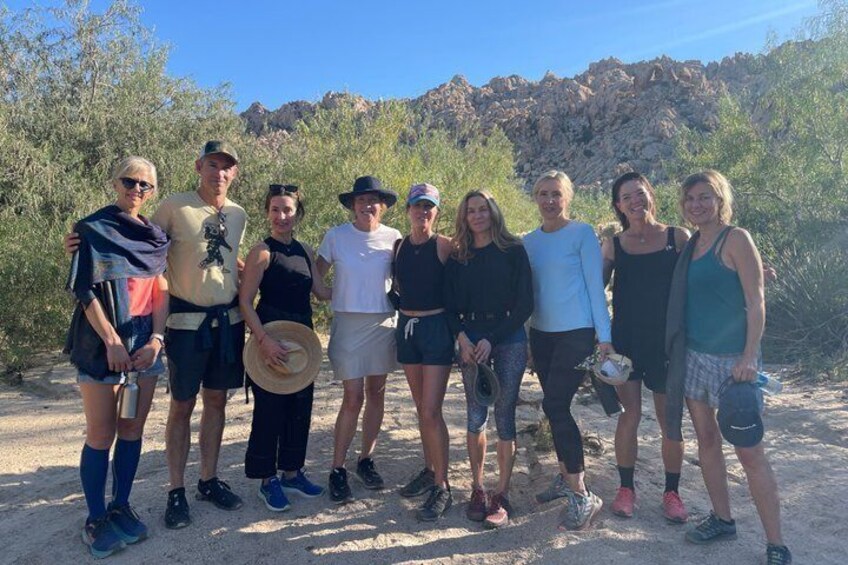 A group of people standing outdoors with a rocky landscape in the background. 4
