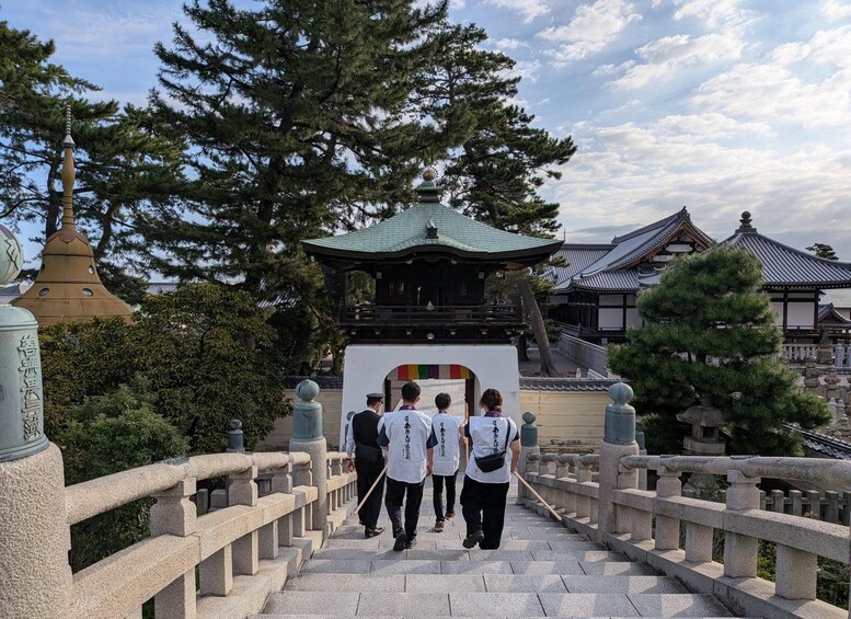 A traditional Japanese temple with a stone bridge leading to the entrance. 2