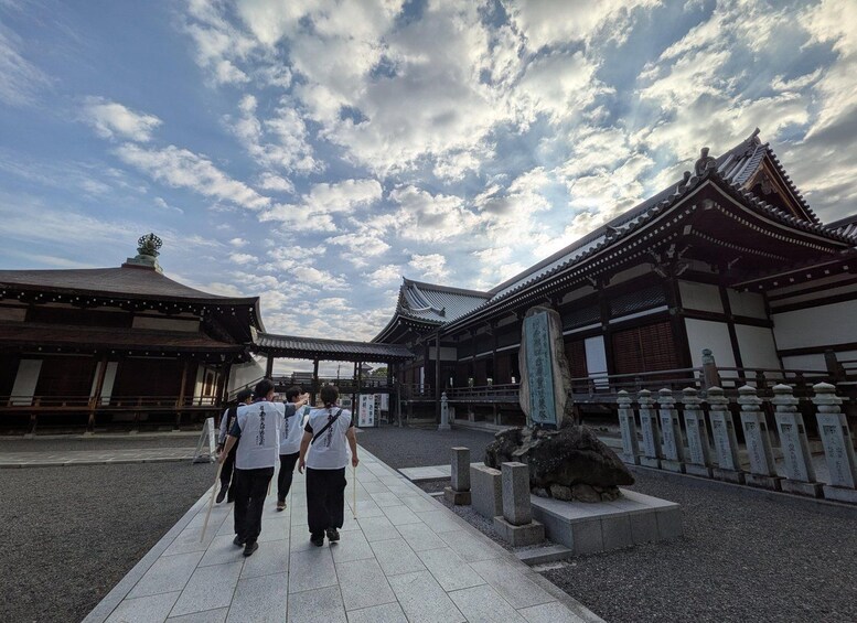 A traditional Japanese temple with a group of people walking in front. 4