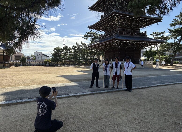 A traditional Japanese pagoda with a group of people standing in front of it. 3