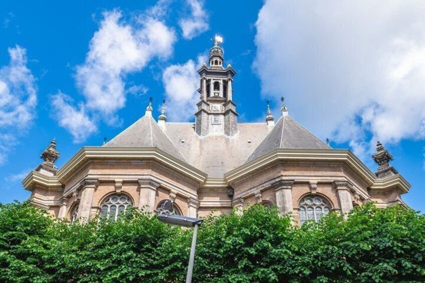 A large, historic building with a prominent bell tower and arched windows. 3