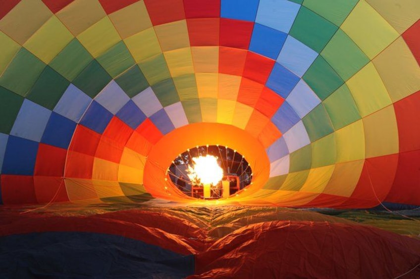 A hot air balloon with a colorful pattern, a basket, and a fire at the bottom. 4