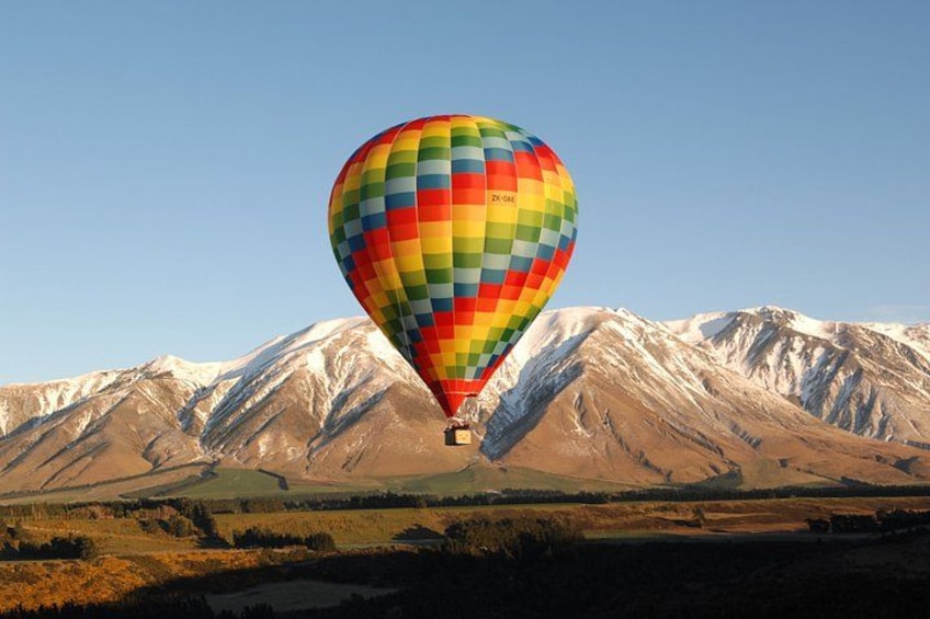 A colorful hot air balloon over a mountainous landscape. 1