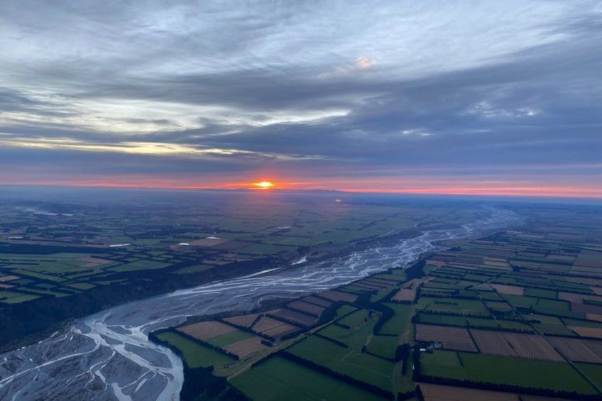 A river winding through agricultural fields during sunset. 3
