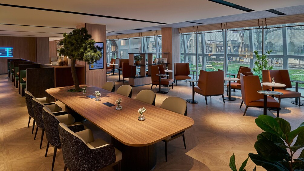 A modern conference room with a long table, chairs, and large windows overlooking a cityscape. 2